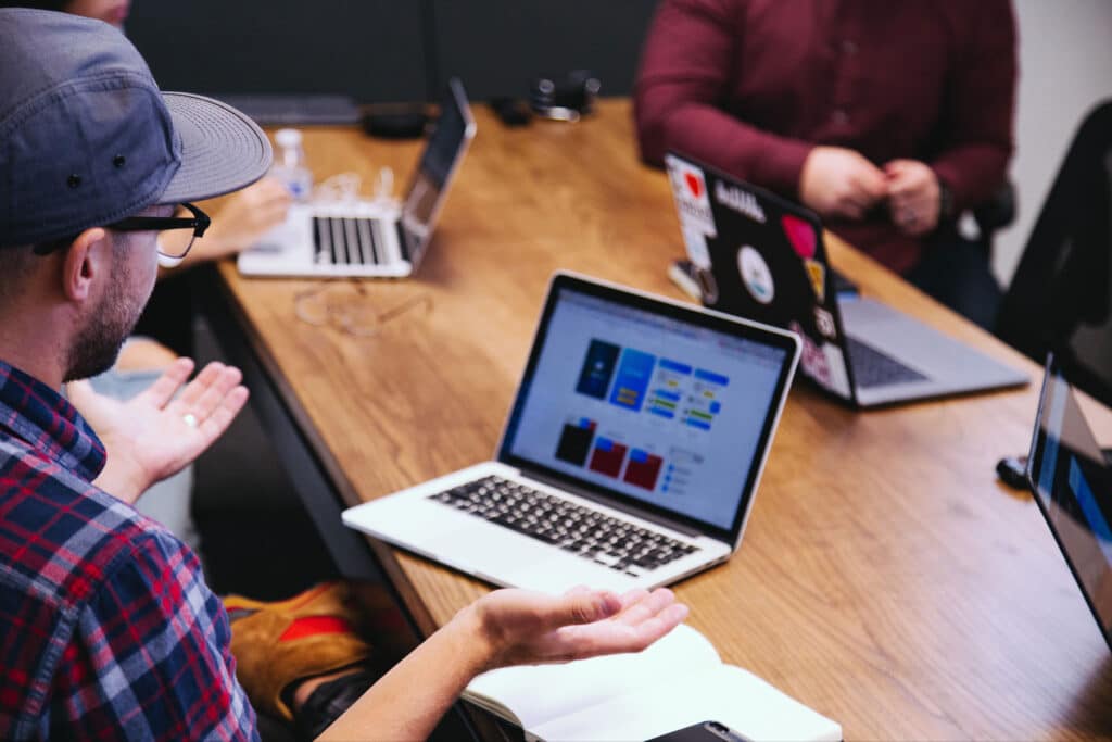 SEO-Experte sitzt im Meeting und bespricht Website in der Desktop-Ansicht.