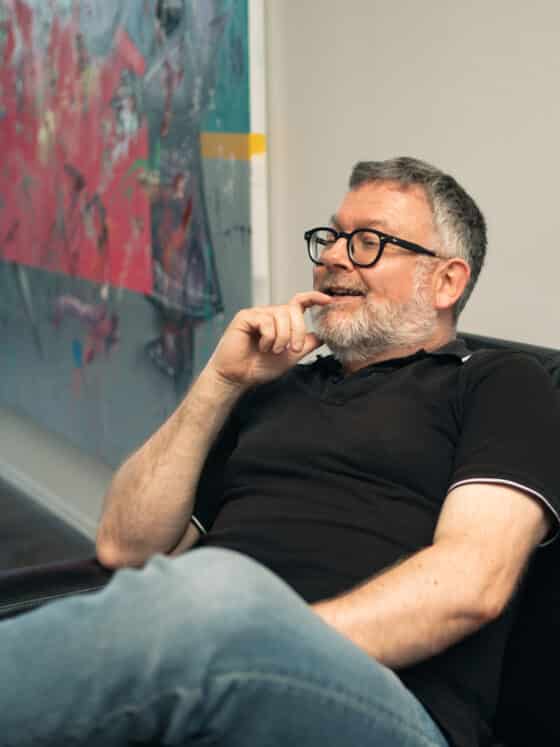 Oliver Wickel, Ticketing Manager bei den Thüringer Bachwochen sitzend auf einem Sofa in seinem Büro neben einem Gemälde