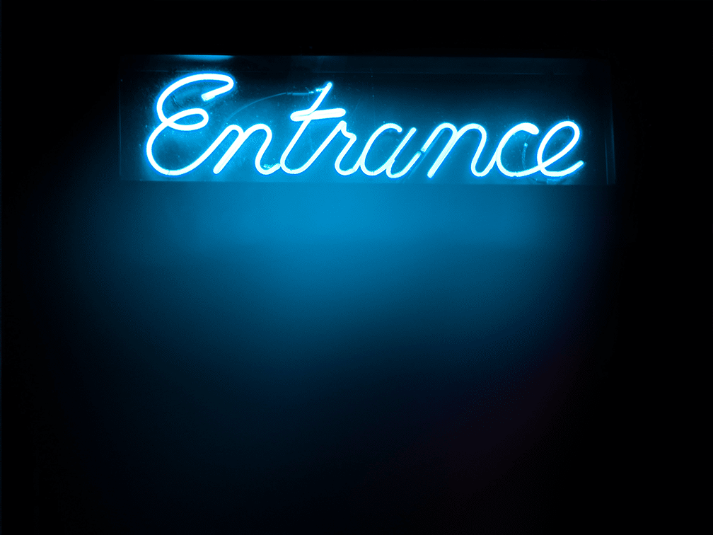 Blauer LED Schriftzug "Entrance" vor schwarzem Hintergrund
