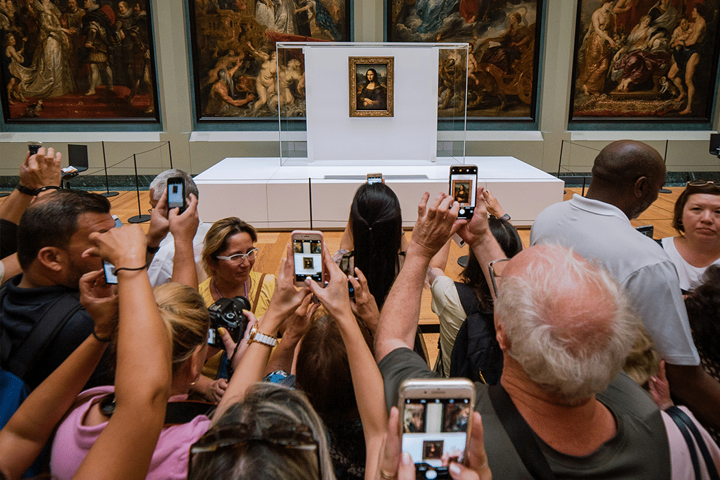 Visitors in front of the Mona Lisa with smartphones raised to take photos