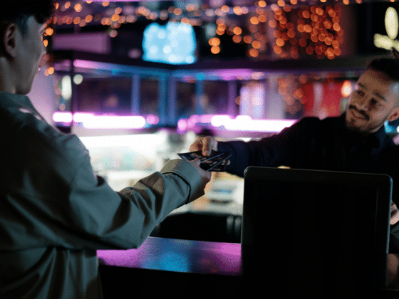 Two men at the cash desk of an event, tickets are handed over