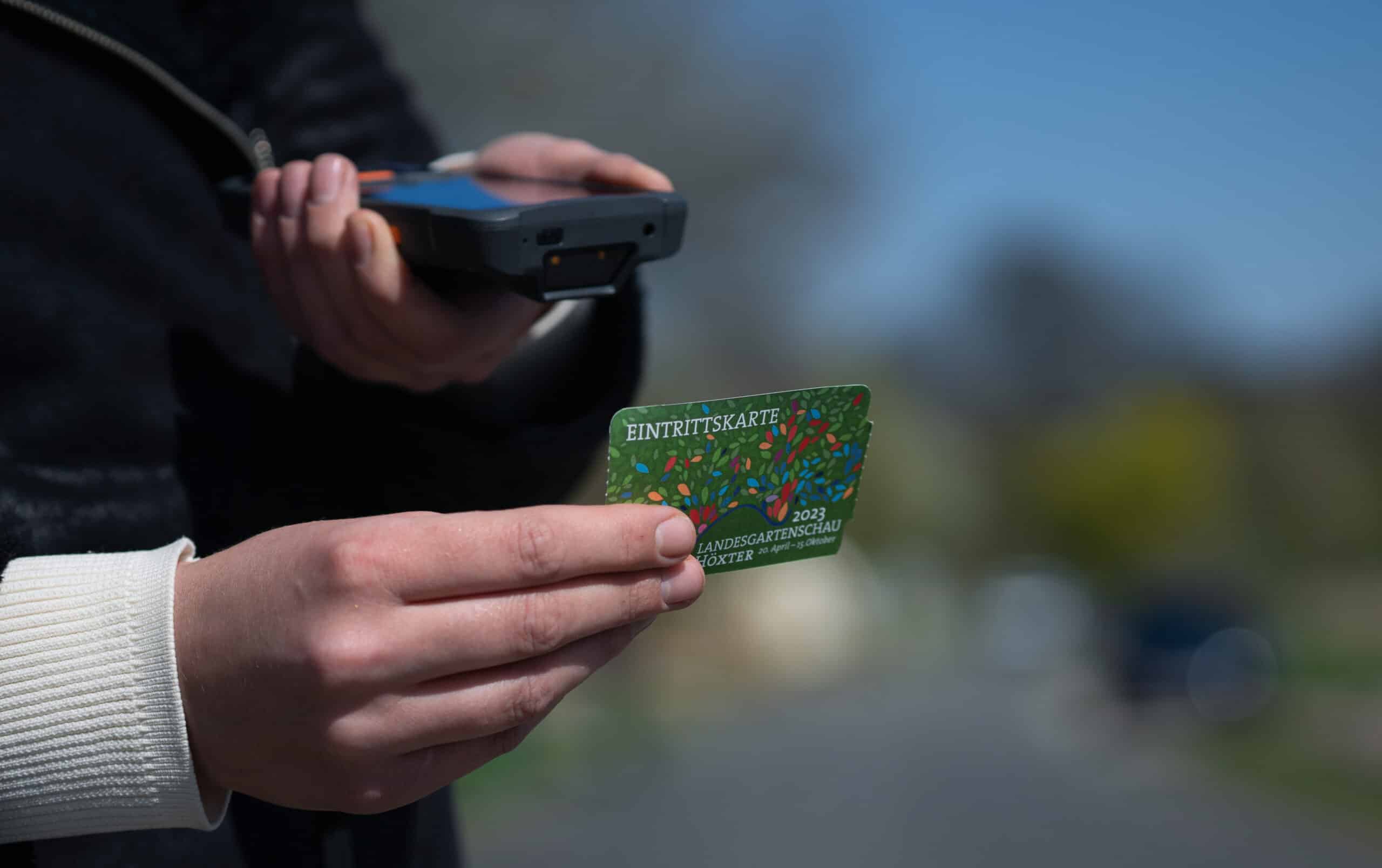 A person scans an admission ticket to the Höxter State Garden Show with a hand scanner