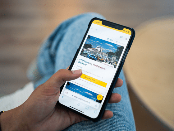 Person hält Smartphone mit geöffnetem Ticketshop, um sich für das Event zu registrieren