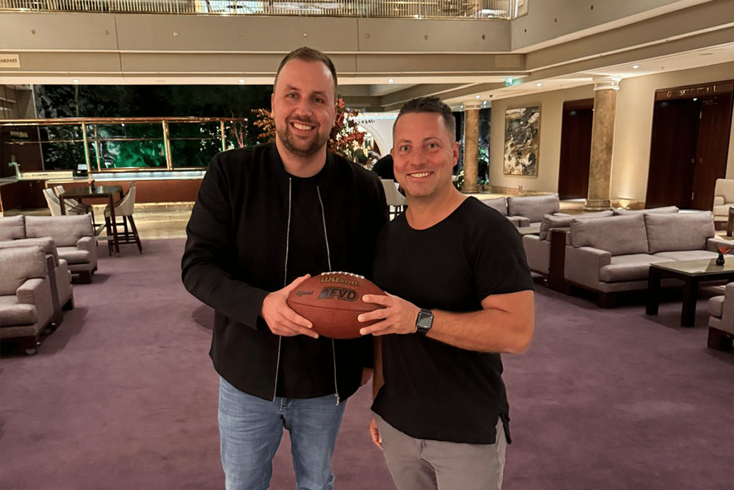 Torben Dill, Geschäftsführer GFL und Sven Müller, CEO egocentric Systems posieren gemeinsma mit einem Football in den Händen