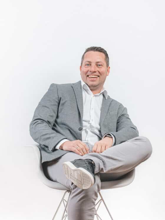 Managing Director Sven Müller sits casually on a chair in front of a bright background