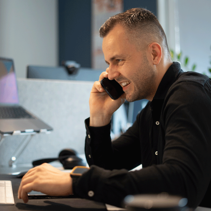 Event expert Moritz Lux, sitting at his desk with his smartphone to his ear. Ready for the next expert interview.