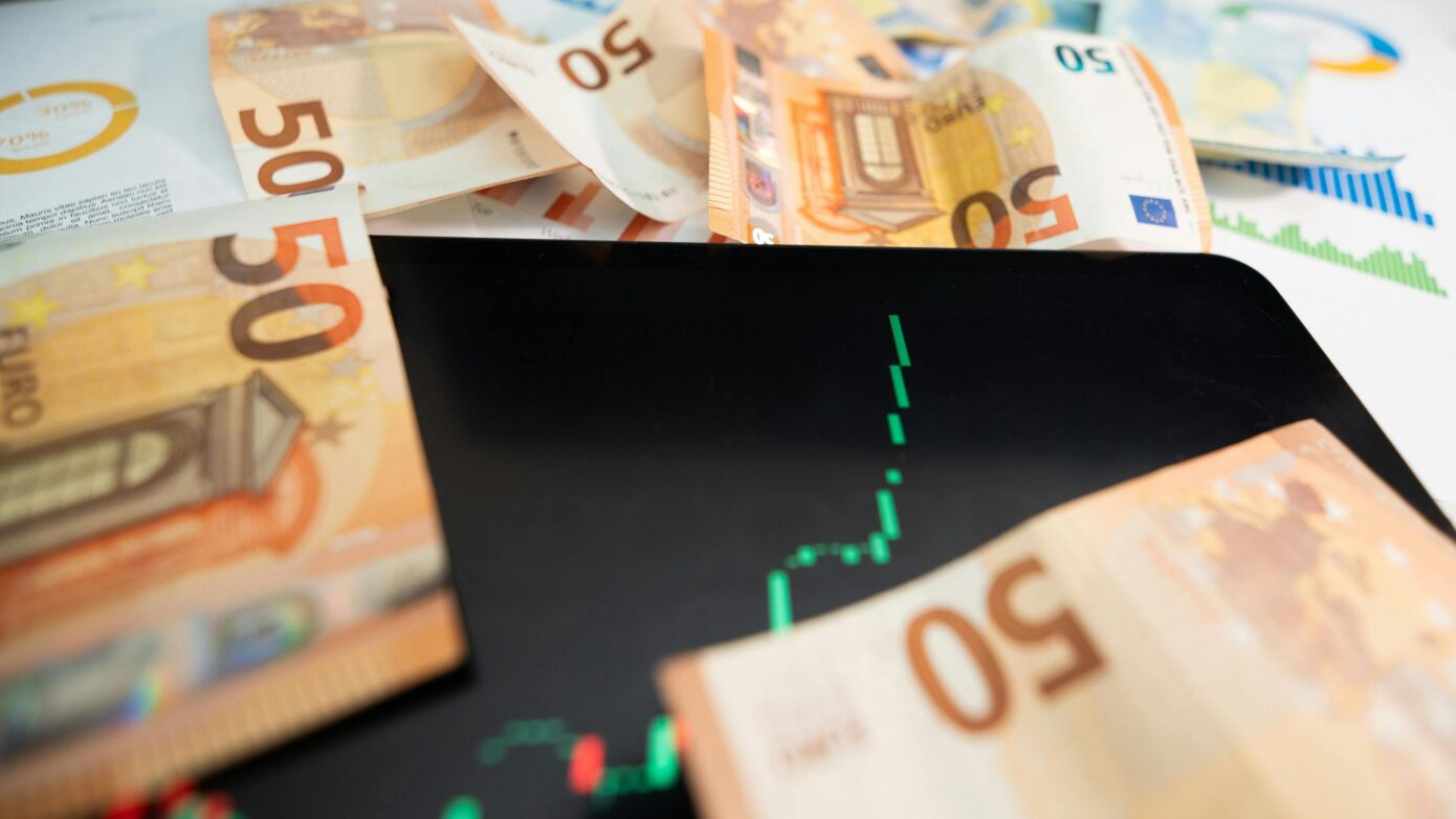 Geldscheine und ein Display mit einem stark anwachsenden Graphen