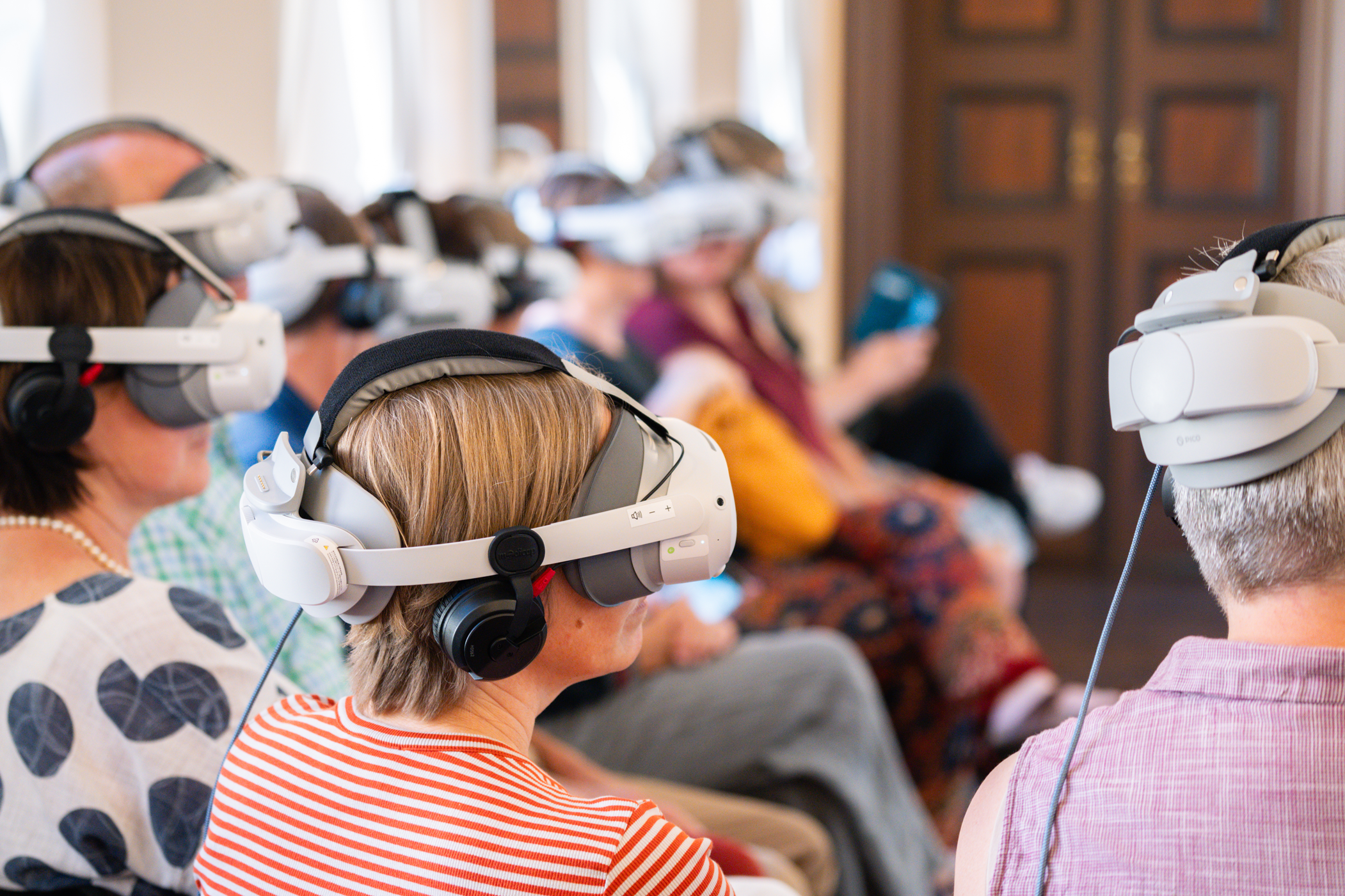 Publikum mit VR-Brillen und Kopfhörern bei der virtuellen Bach-Aufführung